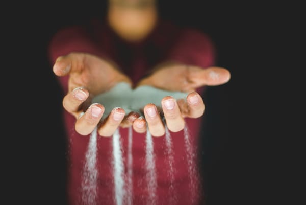 Hands of a woman holding light blue sand